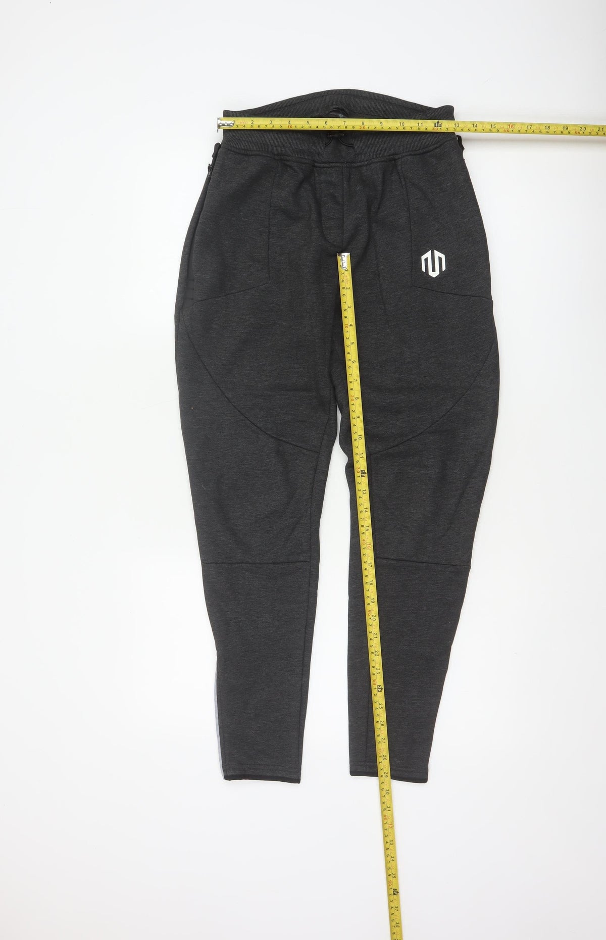 Close-up detail of Morotai unisex grey m performance jogger trousers ankle zip logo