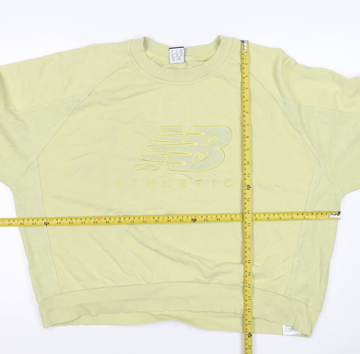 Brand and care label for New Balance Women's Yellow XL Logo Pullover Crew Neck Sweatshirt